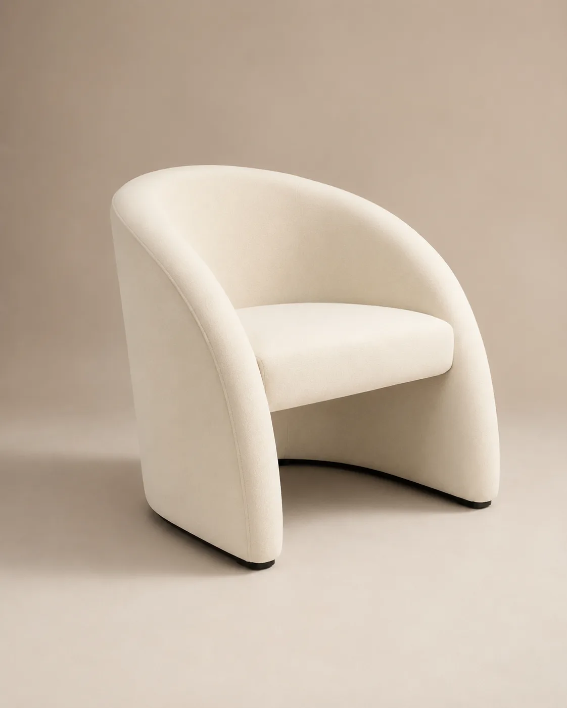 The Colette tub chair — one continuous curve of ivory bouclé from arm to arm.