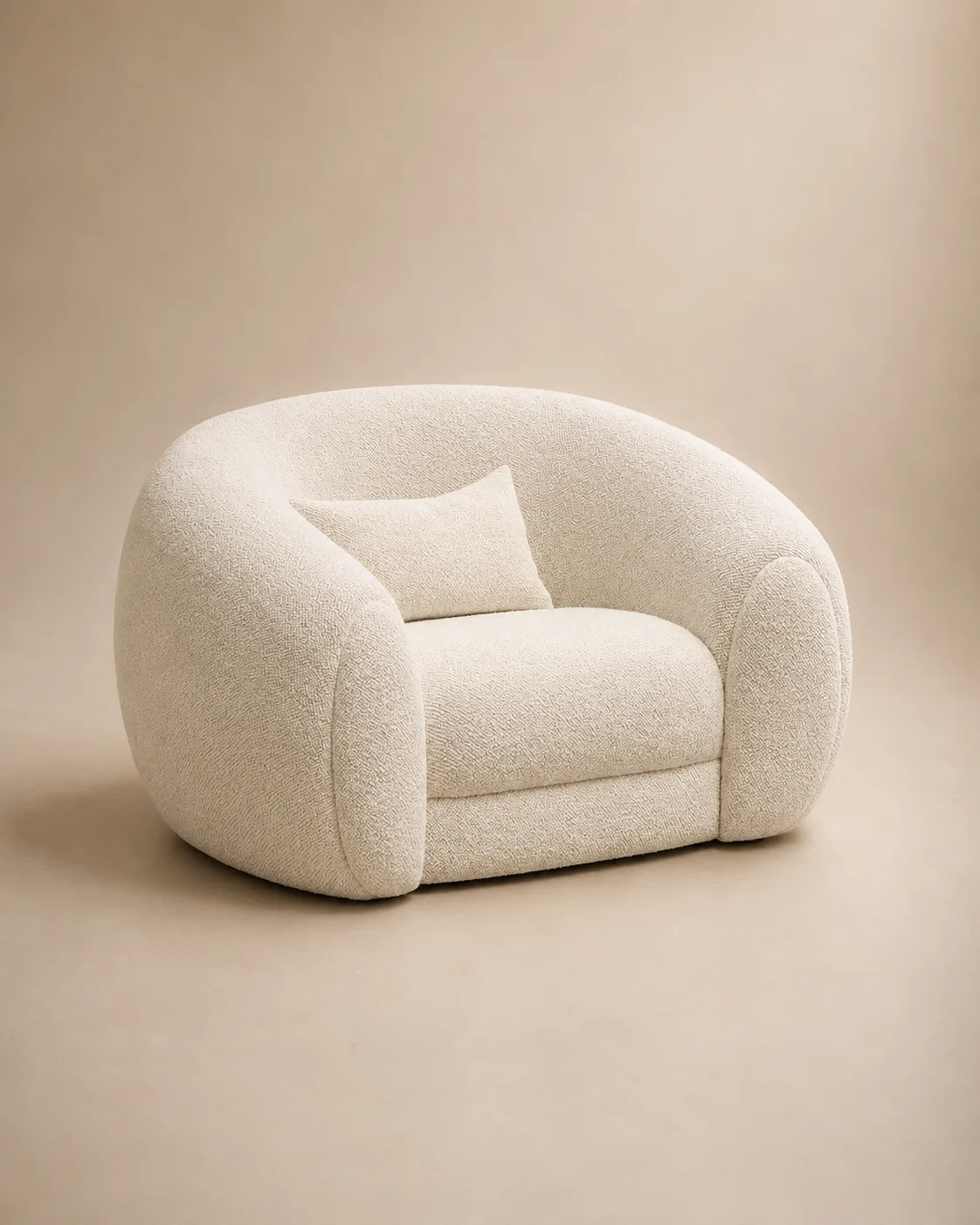 The Lumière lounge chair — a rounded, enveloping ivory bouclé shell with a small lumbar cushion.