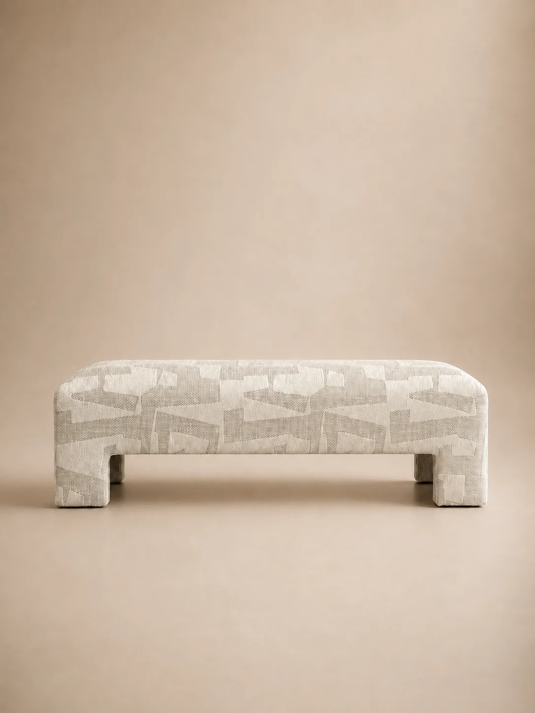 The Margaux bench — a sculptural upholstered shell in a tonal hand-woven jacquard.